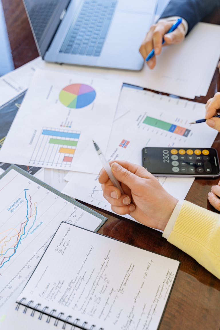 Un primer plano de empresarios analizando ahorros e inversión inteligente durante una reunión.