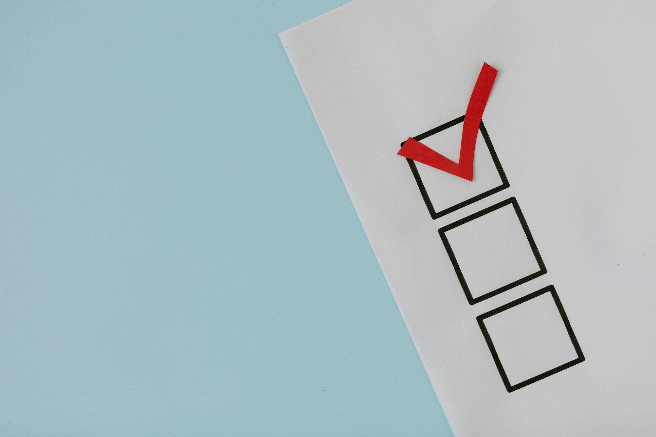 Una simple lista de verificación en papel blanco con una marca de verificación roja, simbolizando disciplina, esencial si se quiere accionar como millonario.