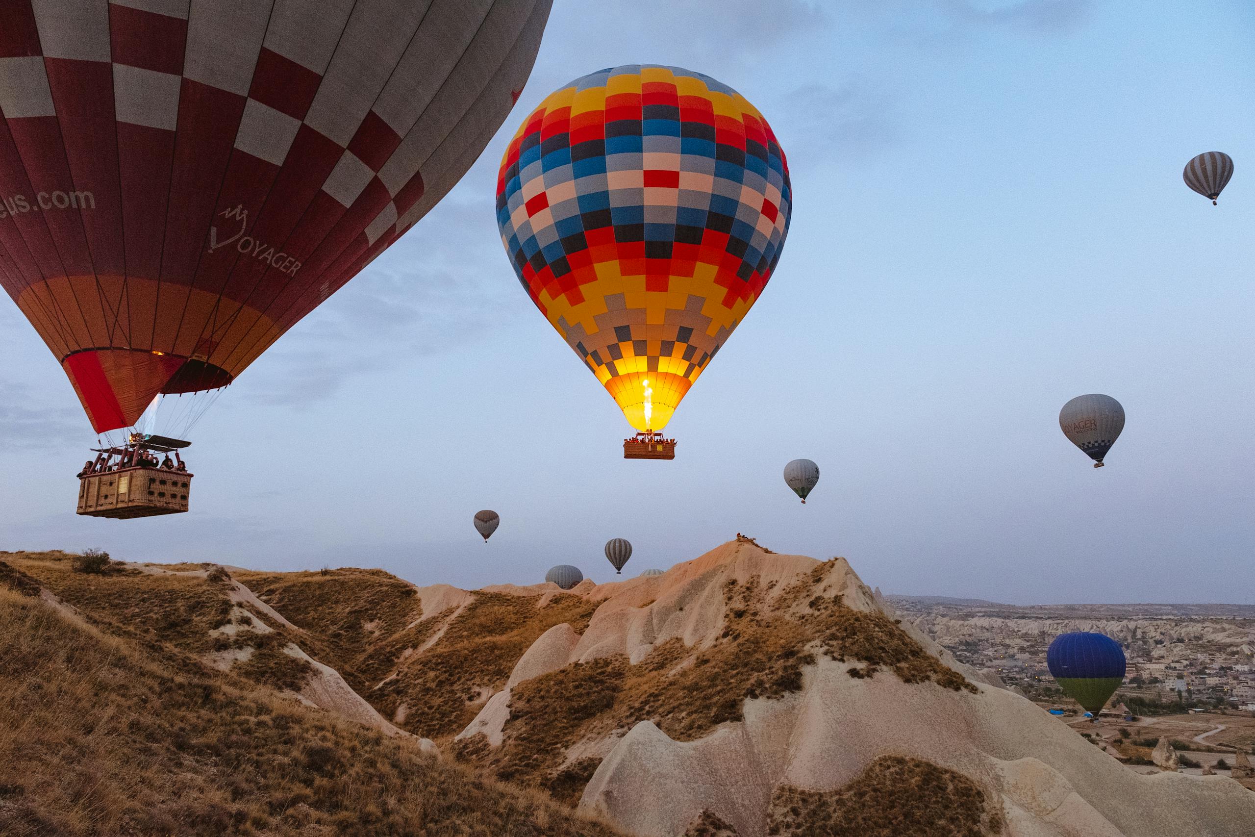 Impresionante vista de coloridos globos aerostáticos volando sobre el paisaje único de Capadocia al amanecer simbolizando soñar en grande.