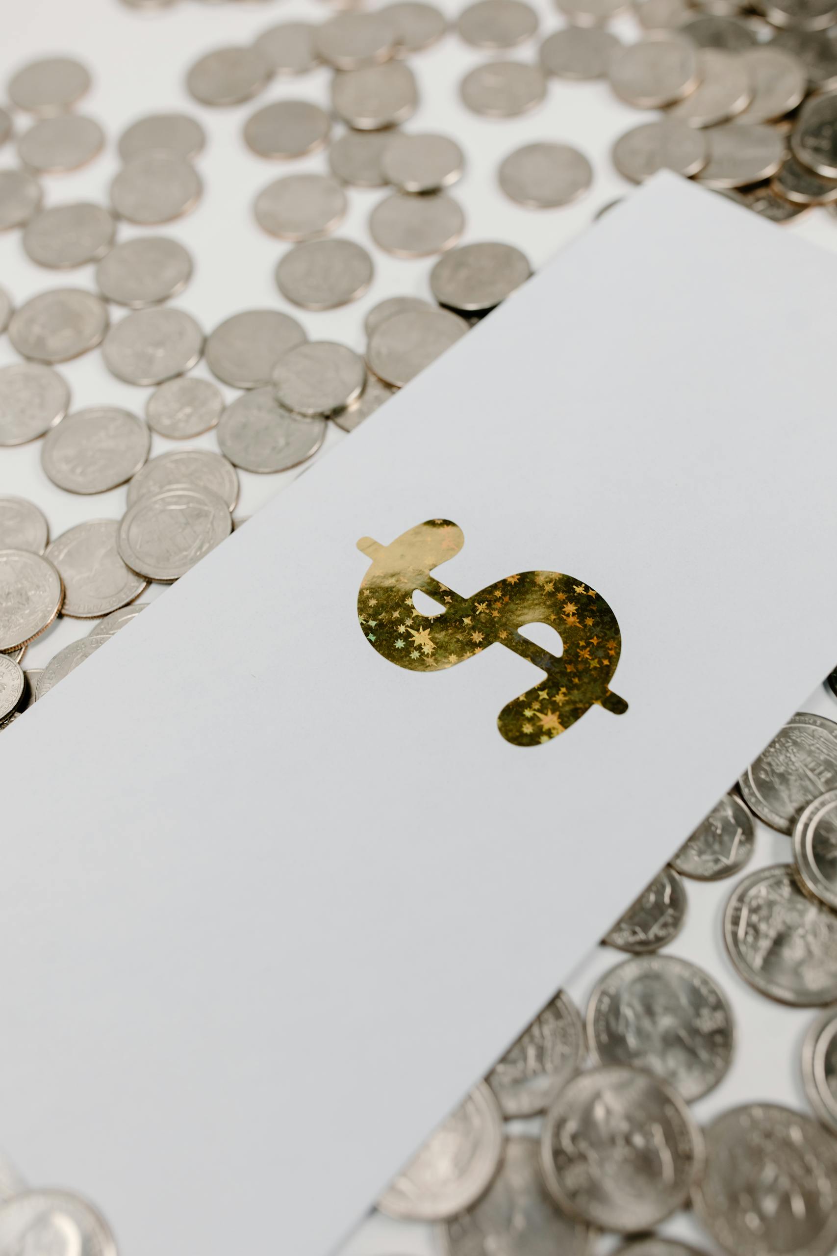 Primer plano de un signo de dólar dorado sobre papel entre monedas dispersas, que simboliza fortuna neta.