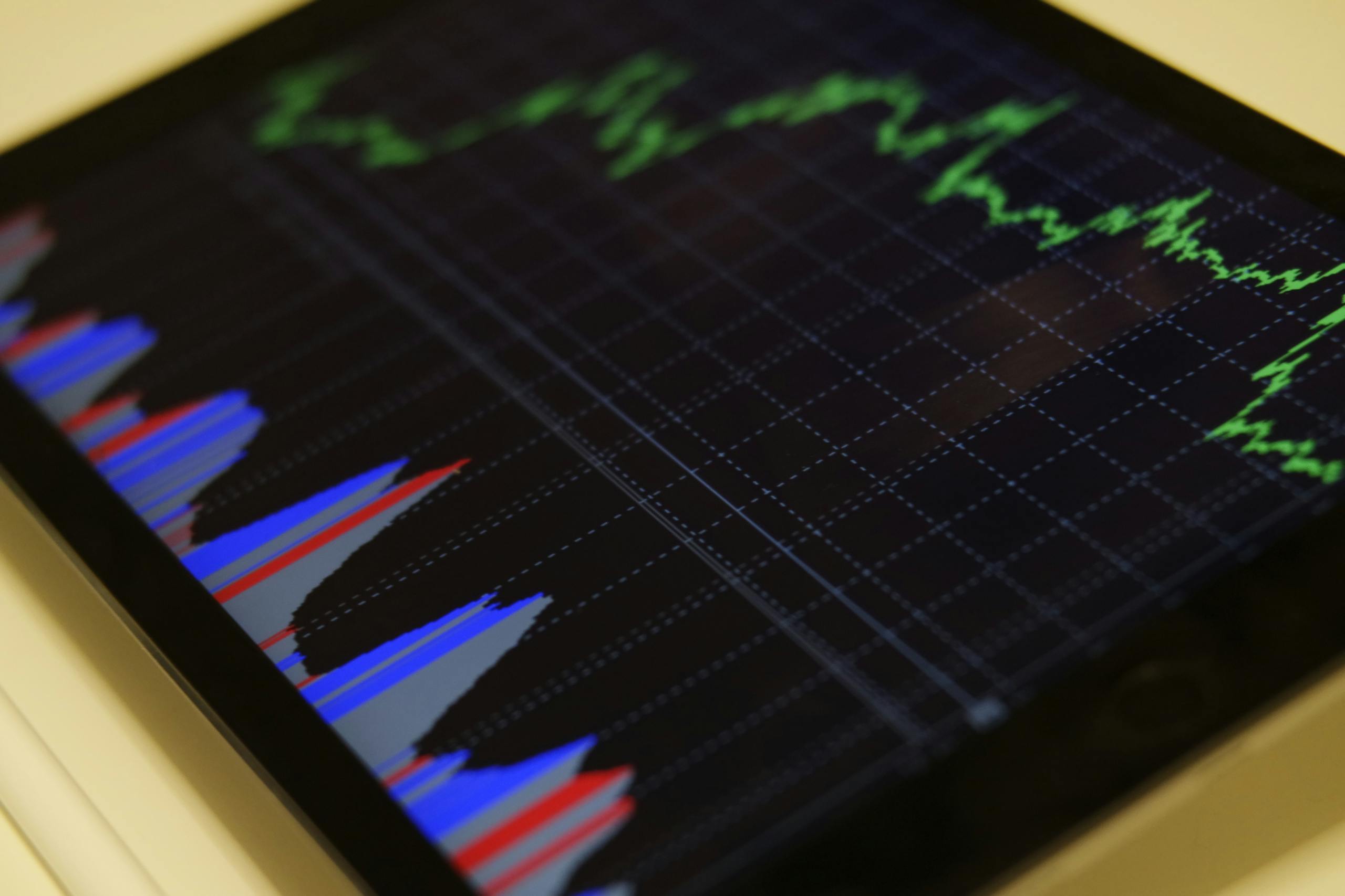 Primer plano de una tableta que muestra un análisis del mercado de valores con gráficos coloridos, representando inversiones al accionar como millonario.