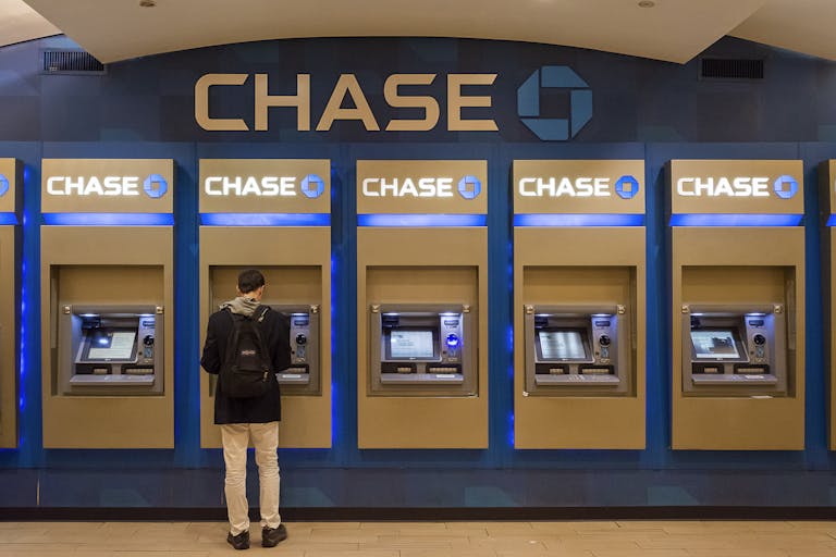 Cliente masculino que utiliza un cajero automático de Chase en un entorno urbano interior simbolizando el uso seguro de tarjetas.