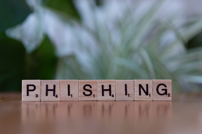 Las baldosas de madera que escriben la palabra 'phishing' resaltan temas de ciberseguridad.
