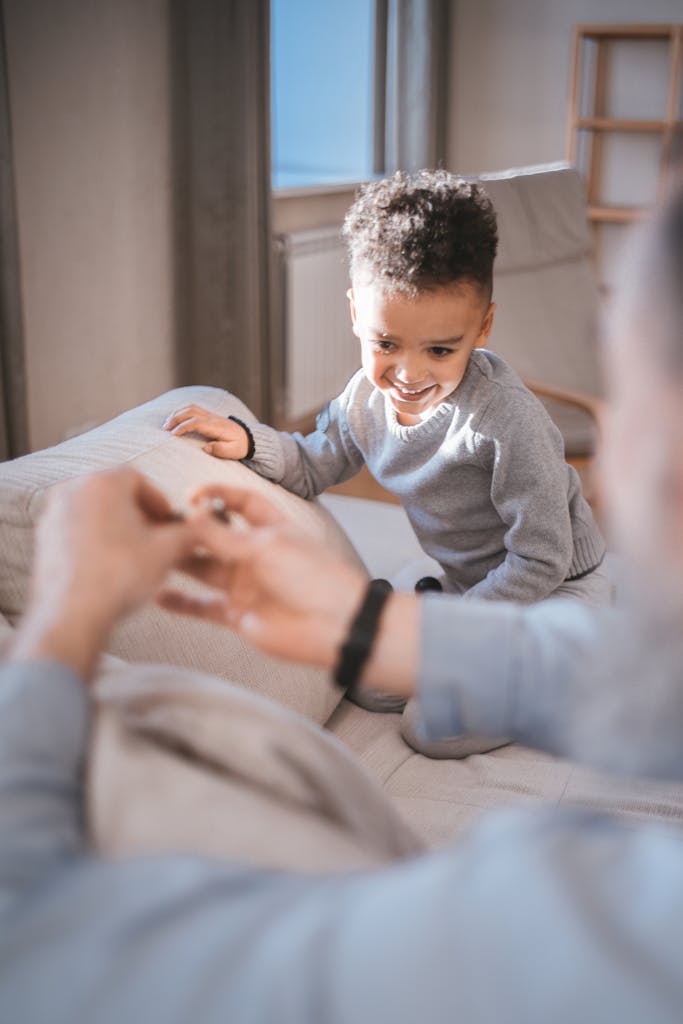Un niño feliz jugando e interactuando con su familia en el interior, representando la importancia de la edad en el perfil de inversor.