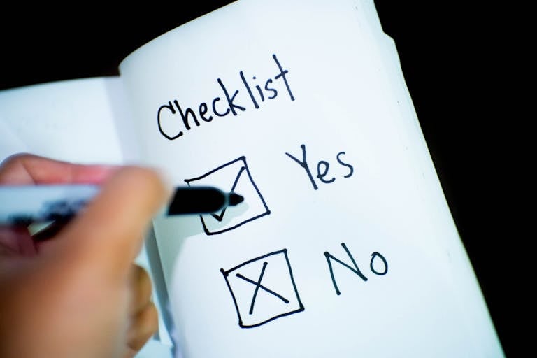 Un cuaderno que contiene una lista de verificación con una casilla marcada como "Sí", representando el cuestionamiento de si endeudarse es bueno o malo.