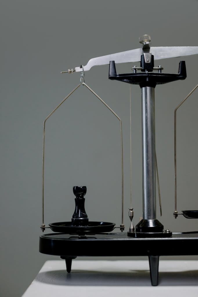 Primer plano de una balanza antigua con una pieza de ajedrez equilibrándose conceptualmente simbolizando un perfil de inversor moderado.